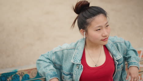 Asian-woman-with-wireless-earphones-in-the-park.