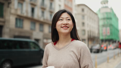 Asian-girl-exploring-city-with-coffee-to-go.