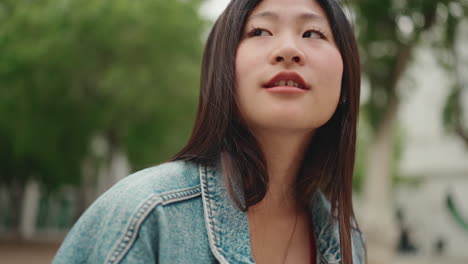 Asian-woman-talking-through-the-phone-in-the-park.