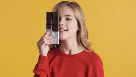 Teenage-Caucasian-girl-holding-chocolate-bar-in-front-of-the-camera.