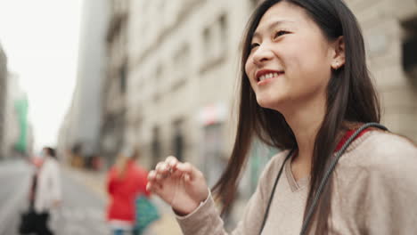 Chica-Asiática-Sosteniendo-Un-Teléfono-Inteligente-Caminando-Al-Aire-Libre.