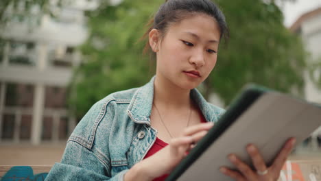 Chica-Asiática-Estudiando-Al-Aire-Libre-Con-Tableta.