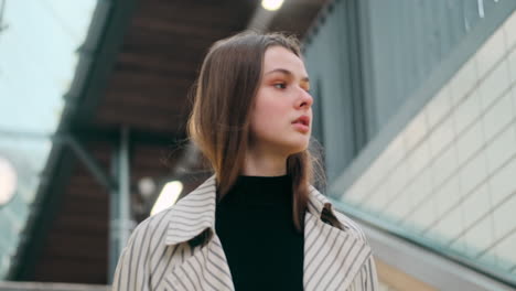 Caucasian-girl-looking-around-confidently-walking-down-the-stairs-at-subway-station.