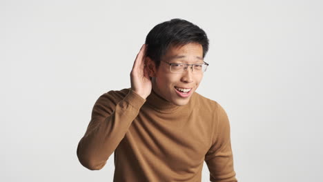 Asian-man-showing-I-don't-hear-expression.
