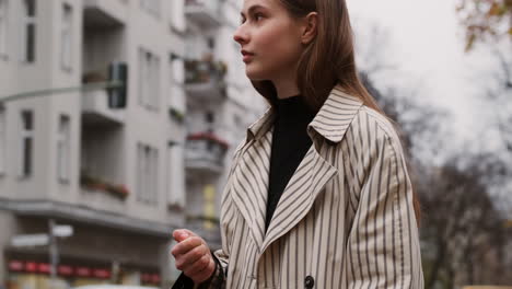 Chica-Caucásica-Elegante-Con-Gabardina-Esperando-En-El-Semáforo-En-La-Calle-De-La-Ciudad.