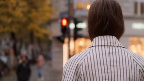 Vista-Posterior-De-Una-Elegante-Chica-Caucásica-Con-Abrigo-Esperando-El-Semáforo-En-La-Calle-De-La-Ciudad.