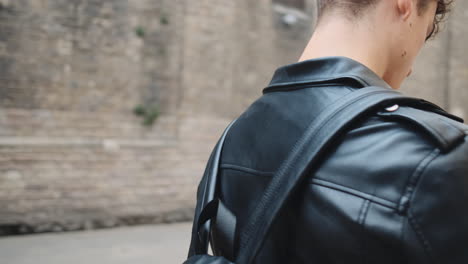 Tracking-around-shot-of-young-stylish-man-using-smartphone-on-city-street