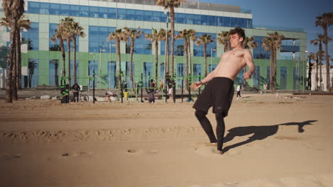 Joven-Musculoso-Atractivo-Haciendo-Volteretas-O-Volteretas-Laterales-Durante-El-Entrenamiento-En-La-Playa-De-La-Ciudad