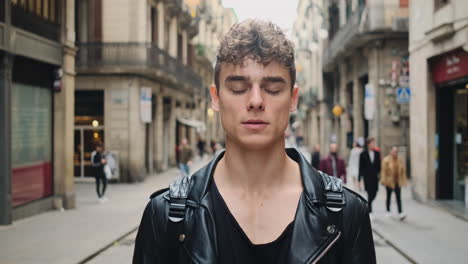 Close-up-shot-of-young-handsome-man-opening-eyes-and-intently-looking-in-camera-outdoor