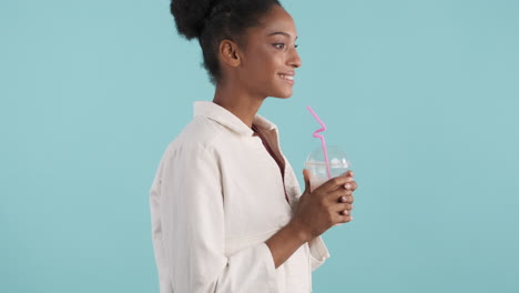 Side-view-of-young-woman-drinking-delicious-milkshake