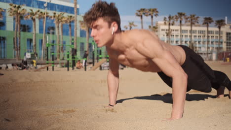 Kamerafahrt-Eines-Jungen-Muskulösen-Mannes,-Der-Sich-Beim-Funktionstraining-Am-Strand-Hochdrückt.-Fitter-Typ-Beim-Training-Im-Freien