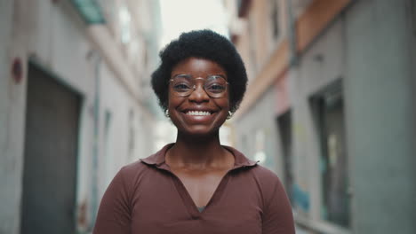Fröhliche-Afrikanische-Frau-Mit-Brille,-Die-Draußen-Glücklich-Aussieht