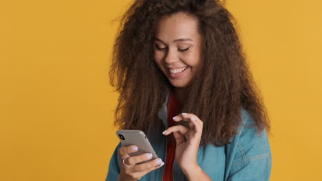 Caucasian-curly-haired-woman-scrolling-on-smartphone.