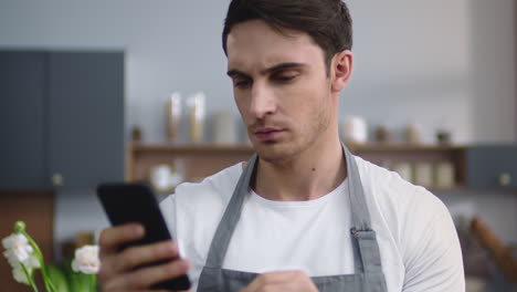 Chef-looking-phone-screen-in-the-kitchen.
