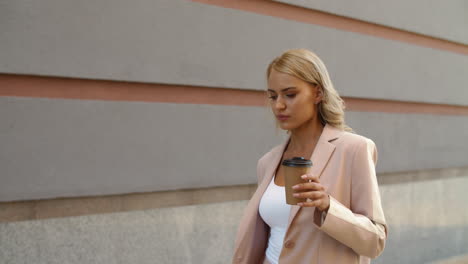 Close-up-view-of-woman-walking-holding-coffee-on-the-street