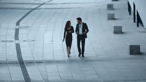 Young-business-couple-talking-in-stylish-clothing-outside