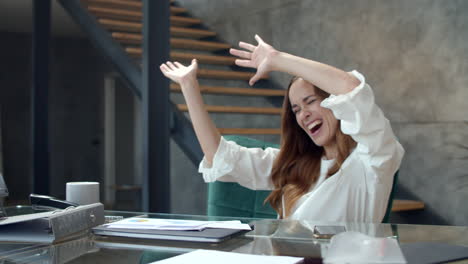 Young-business-woman-getting-excited-with-documents-at-remote-office
