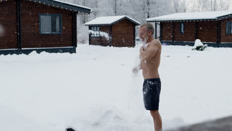 Man-scrubbing-his-body-with-snow