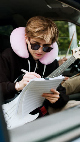 Woman-holding-guitar-and-sheet-music