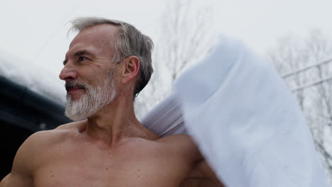 Happy-man-in-shorts-with-towel-on-winter