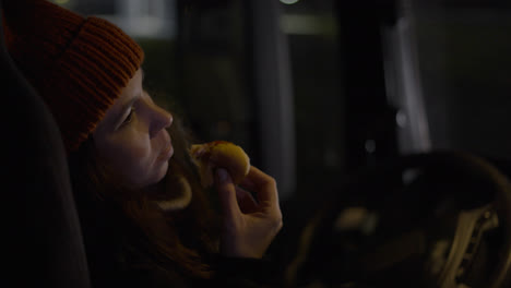 Female-driver-eating-hotdog-and-drinking