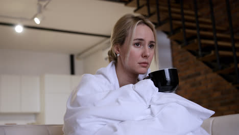 Young-woman-holding-black-mug-at-home
