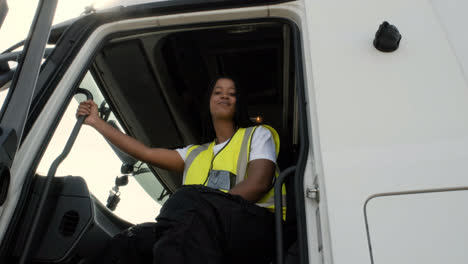 Driver-sitting-on-her-truck,-putting-a-cap-on