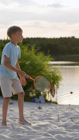 Junge-Spielt-Badminton-Am-Strand