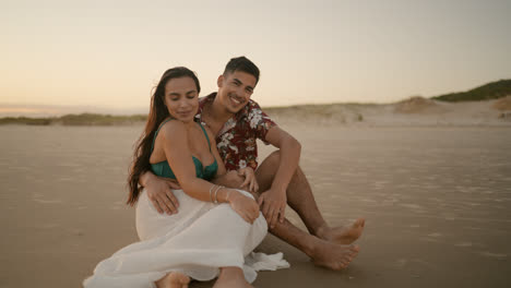 Glückliches-Paar,-Das-Auf-Dem-Sand-Sitzt-Und-Posiert