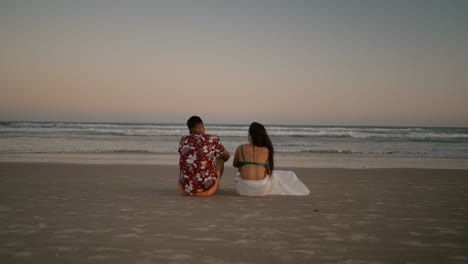 Glückliches-Paar,-Das-Auf-Dem-Sand-Sitzt