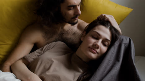 Woman-laying-on-his-boyfriend-in-bed