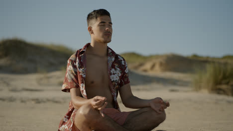 Junger-Mann-Meditiert-Am-Strand