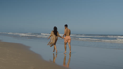 Cute-couple-running-at-the-beach