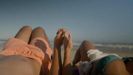 Young-couple-sunbathing-at-the-beach