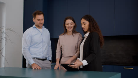 Female-agent-talking-with-clients-in-the-kitchen