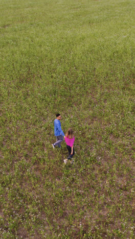 Young-couple-holding-hands-in-a-field