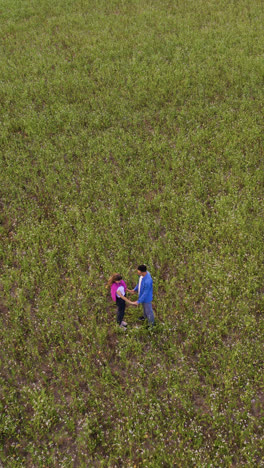 Young-couple-holding-hands-in-a-field
