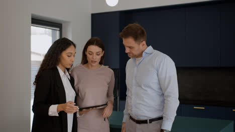 Female-agent-talking-with-clients-in-the-kitchen