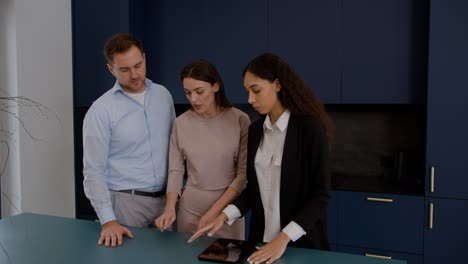 Female-agent-talking-with-clients-in-the-kitchen