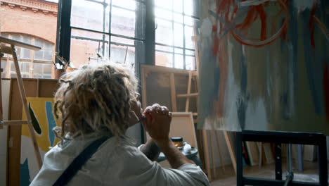 Artist-sitting-in-front-of-painting