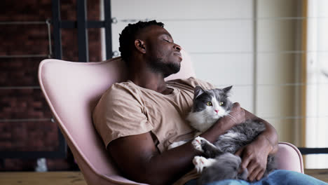 Pet-owner-with-his-cat-on-a-chair