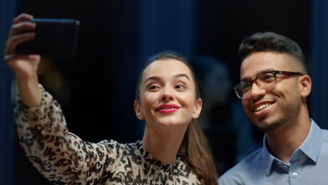 Portrait-of-colleagues-using-cellphone-for-selfie-indoors