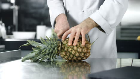 Chef-chopping-pineapple-with-knife-in-slow-motion