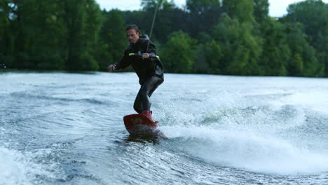 Young-man-wakeboarding-on-river-wave