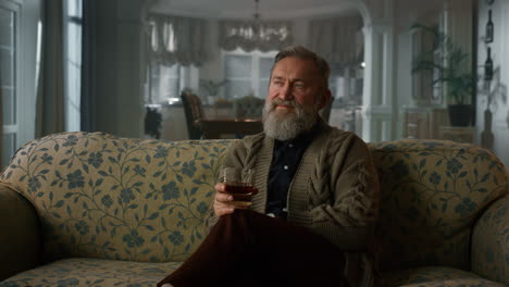 Senior-man-drinking-cognac-in-the-living-room