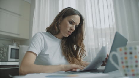 Focused-business-woman-working-with-papers-at-home