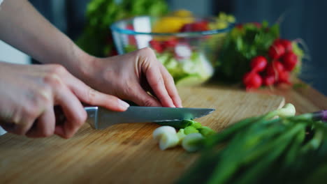 Woman-cutting-green-onion-for-salad