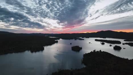 Blue-Mountain-Lake-Against-Cloudy-Sunset-Sky-In-New-York,-USA---Aerial-Drone-shot
