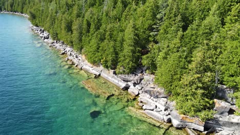 Discovering-green-forest-and-rocky-coastline-with-turquoise-waters-in-Georgian-Bay-in-Ontario,-Canada