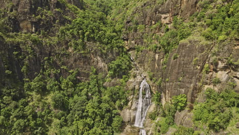 Ella-Sri-Lanka-Aerial-V43-Drohnen-Vorbeiflug-An-Den-Ravana-Wasserfällen,-Aufnahme-Eines-Atemberaubenden-Blicks-Auf-Das-Wasser,-Das-Die-Klippenwand-Hinunterfließt,-Und-Die-Dichte,-üppige-Dschungelvegetation-–-Aufgenommen-Mit-Mavic-3-Cine-–-April-2023